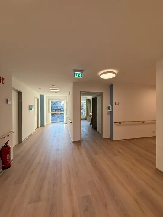 Langer Flur mit Vinylboden und Handlauf