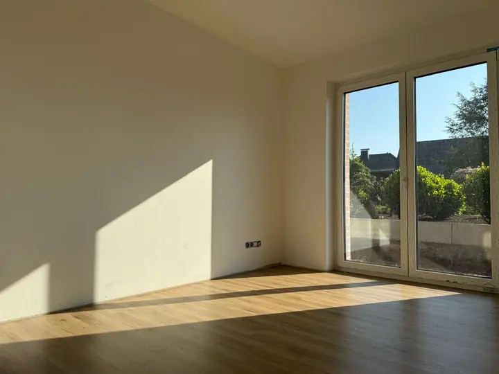 Wohnraum mit Vinylboden und großer Fensterfront