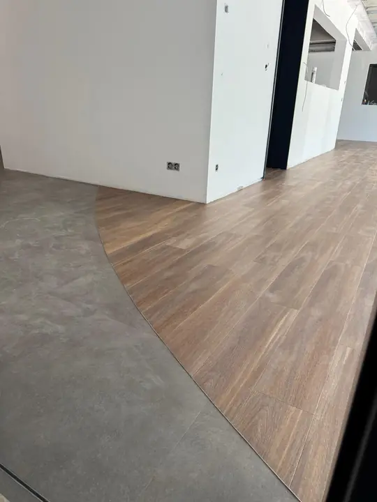 Geschwungener Übergang zwischen Boden in Betonoptik und Holzoptik